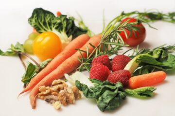 Vegetais com cenoura, tomate, alecrim, amora, nozes e folhosos verde escuro